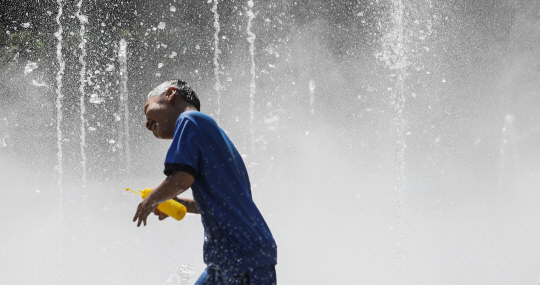 대구 낮 최고기온이 32.5도까지 오르며 더운 날씨를 보인 16일 오후 대구 서구 꼼지락공원 바닥분수에서 아이들이 물놀이를 하며 더위를 식히고 있다. [대구=연합뉴스]